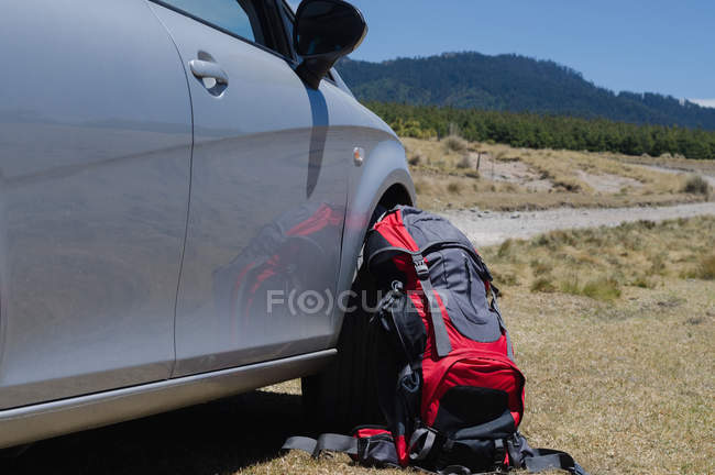 Bag by car on field during sunny day — Stock Photo