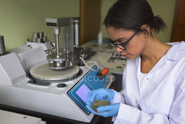 Estudiante adolescente usando maquinaria en laboratorio en la universidad - foto de stock
