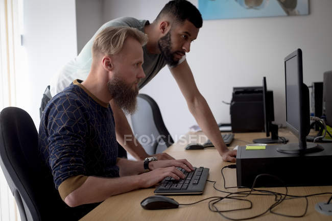 Colleagues working together at desk in office — Stock Photo