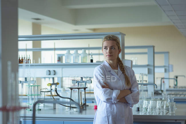 Ragionevole studente universitario in piedi con le braccia incrociate in laboratorio — Foto stock