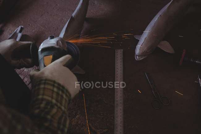 Handwerker sägt Metall mit Elektrowerkzeug in Werkstatt — Stockfoto
