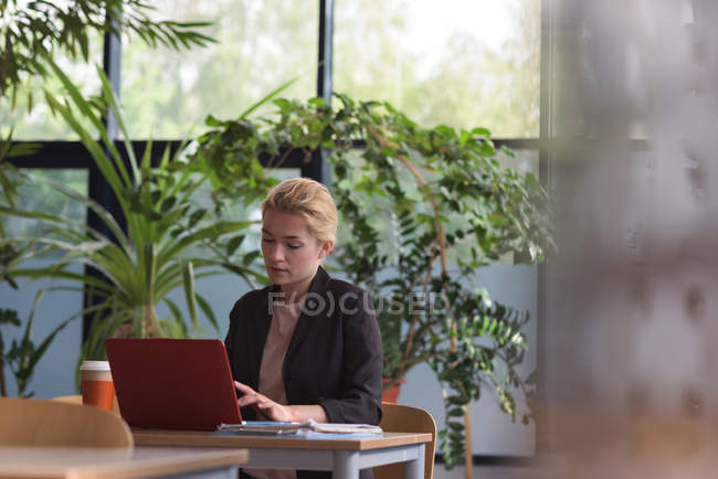 Attentive university student using laptop in college — Stock Photo