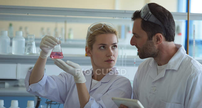 Étudiants universitaires faisant des expériences ensemble en laboratoire — Photo de stock