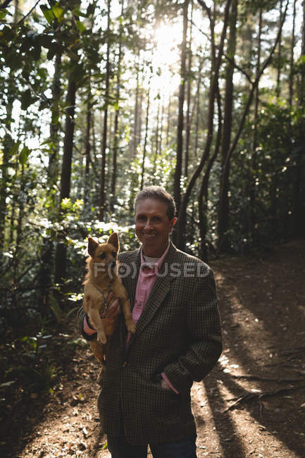 Зрілий чоловік зі своєю собакою у лісі — стокове фото