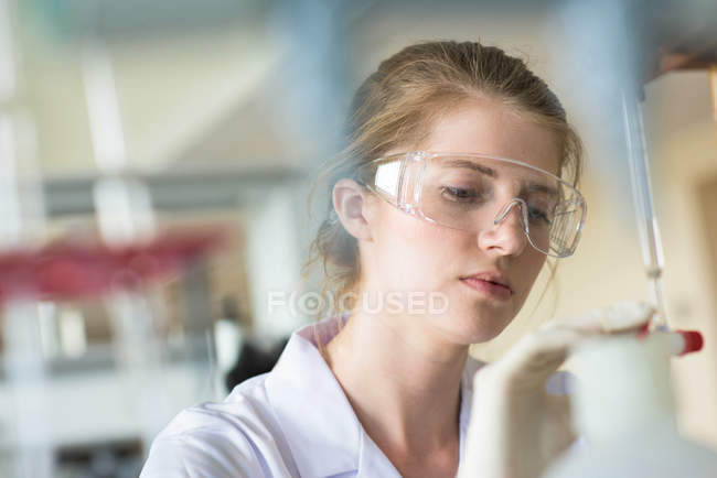 Close-up de estudante do sexo feminino que pratica experiência em laboratório — Fotografia de Stock