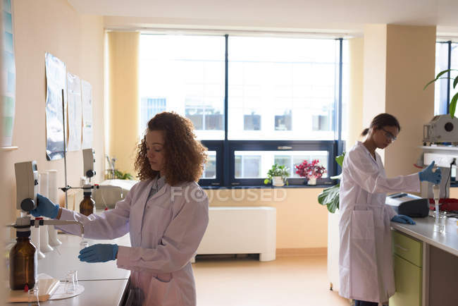 Жіночі студенти проводять хімічний експеримент у лабораторії. — стокове фото