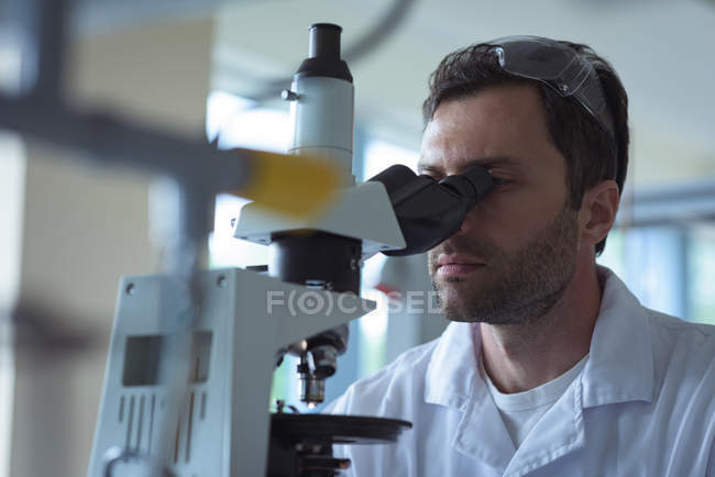 Universitätsstudent experimentiert im Labor der Hochschule am Mikroskop — Stockfoto