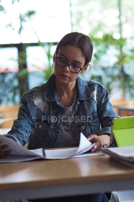 Studente universitaria donna che studia alla scrivania in classe — Foto stock