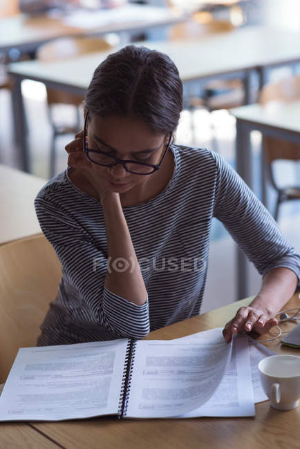 High angle view of female student studying at desk in classroom — Stock Photo