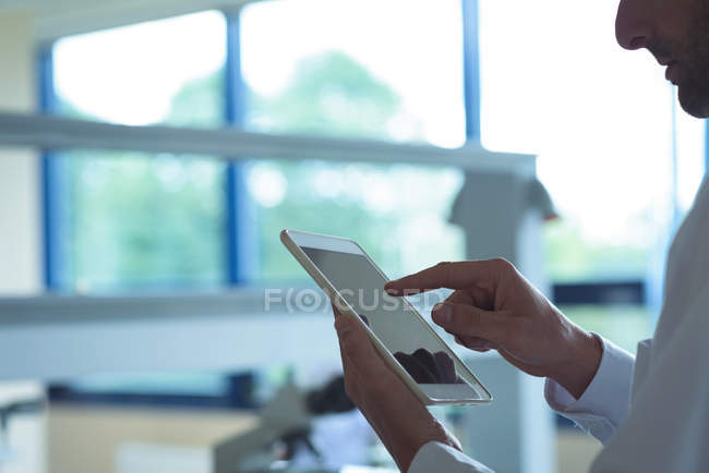 Attentive university student using digital tablet in laboratory — Stock Photo