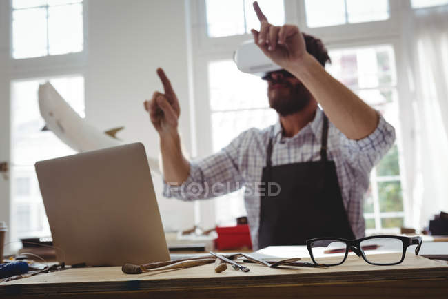 Craftsman using virtual reality headset at desk — Stock Photo
