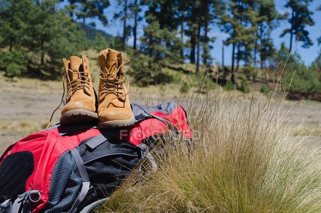 Close up of boots with backpack on field — Stock Photo