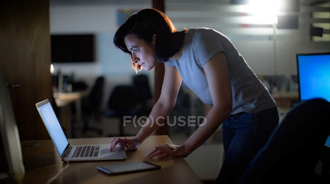 Виконавчий використовує ноутбук за столом в офісі — стокове фото