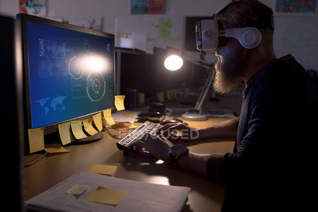 Виконавчий директор використовує шолом віртуальної реальності під час роботи за столом в офісі — стокове фото