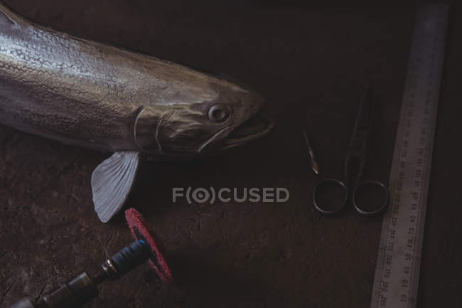 Pescado metálico y herramienta de mano en encimera en taller - foto de stock
