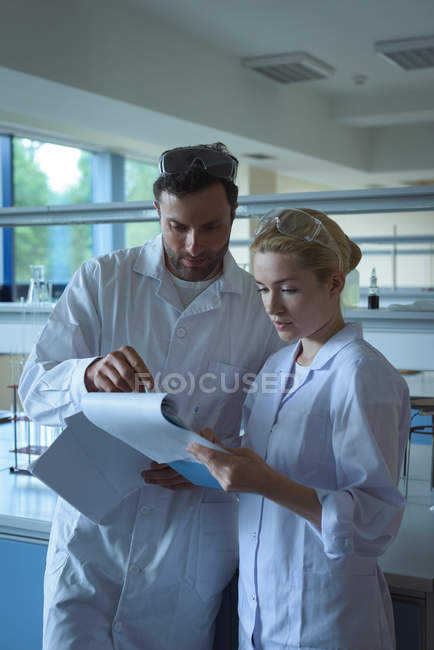 University students discussing reports in laboratory at college — Stock Photo