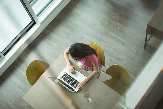 Вид сверху на женщину, использующую ноутбук в гостиной дома — стоковое фото