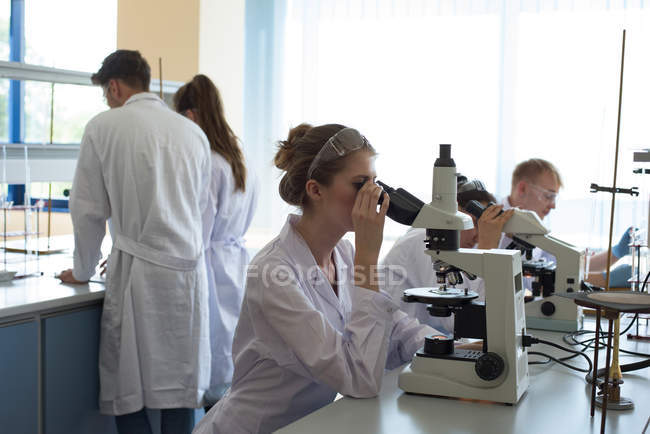 Estudantes universitários praticando experiência científica em laboratório — Fotografia de Stock