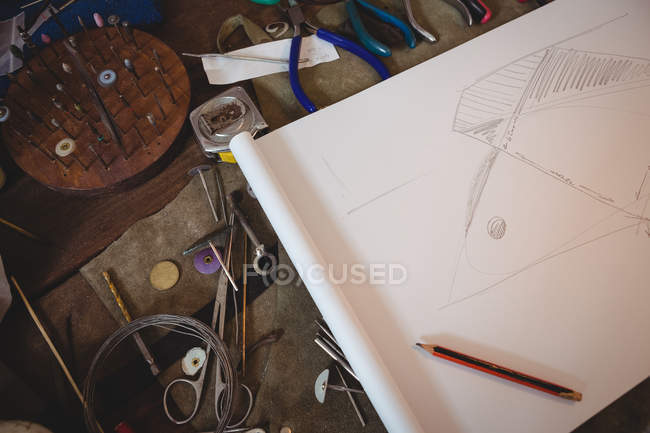 Various tools and sketch paper on worktop in workshop — Stock Photo