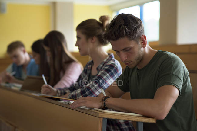 Студенти університету сидять за столом у класі — стокове фото