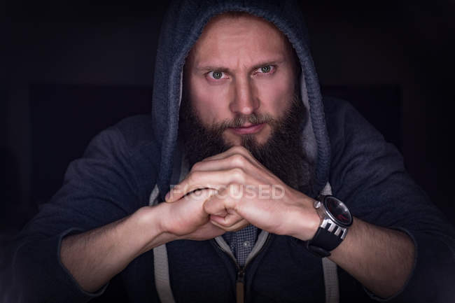 Thoughtful executive in hoodie sitting at office — Stock Photo