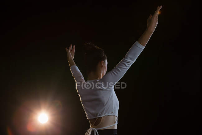 Vue arrière de la ballerine pratiquant la danse de ballet sur scène — Photo de stock