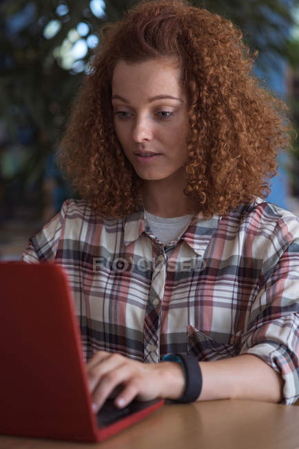 Adolescente utilisant un ordinateur portable tout en étant assis dans la salle de classe — Photo de stock