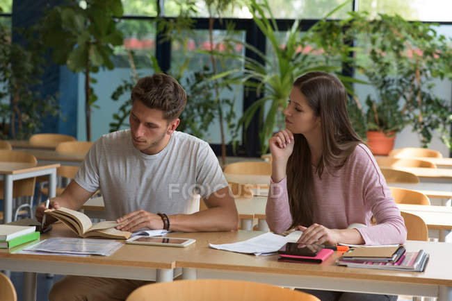 Young student studying at desk om classroom — Stock Photo