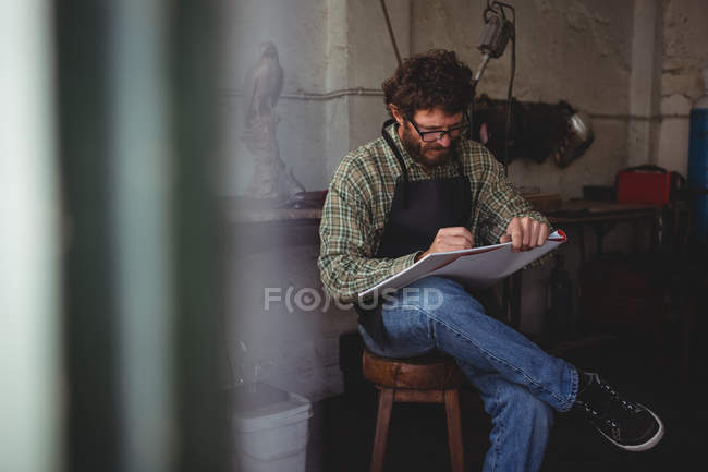 Ремесленник рисует скульптуру в мастерской — стоковое фото