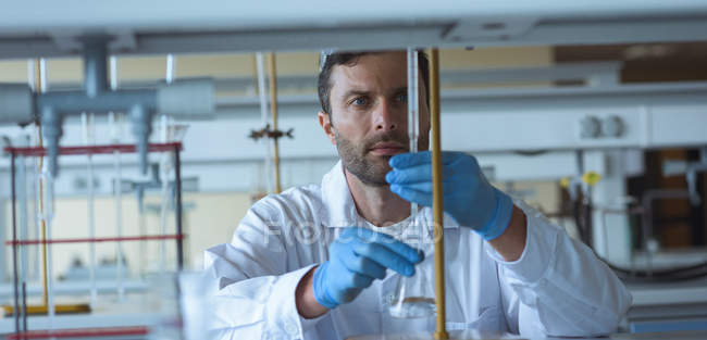 Estudante universitário atento fazendo uma experiência química em laboratório — Fotografia de Stock