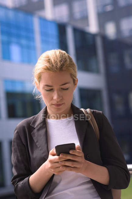 University student using mobile phone in campus at college — Stock Photo