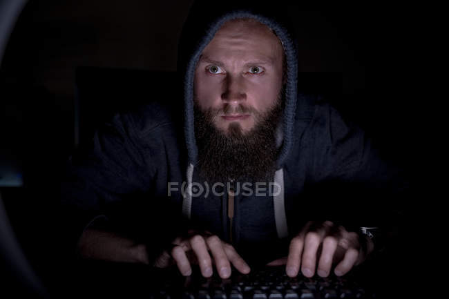 Executive in hoodie working at desk in office — Stock Photo