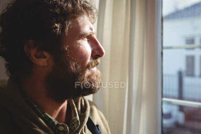 Artigiano che guarda attraverso la finestra in officina — Foto stock
