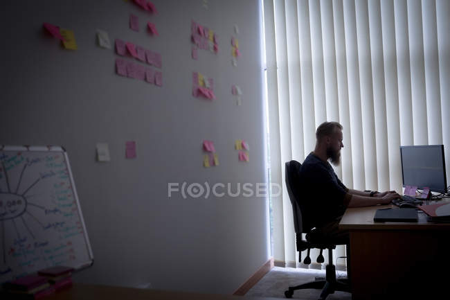 Executivo trabalhando em computador pessoal na mesa no escritório — Fotografia de Stock