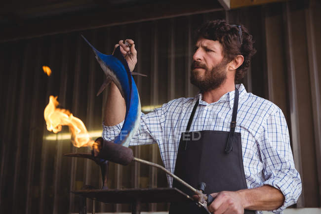Artigiano che prepara scultura di pesce in laboratorio — Foto stock