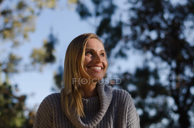 Close up of cheerful female hiker against trees — Stock Photo
