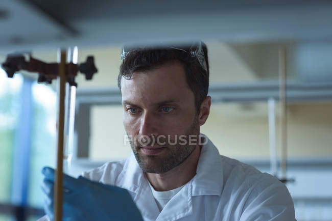 Studente universitario attento che fa un esperimento chimico in laboratorio — Foto stock