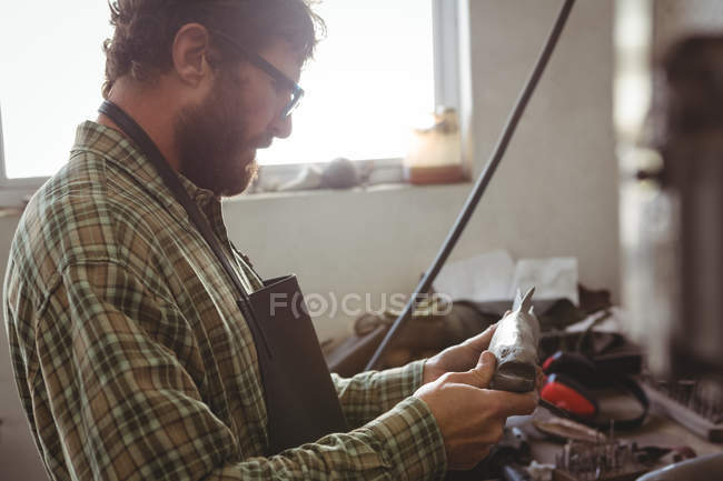 Уважний майстер вивчення металевої риби на робочому майстерні — стокове фото
