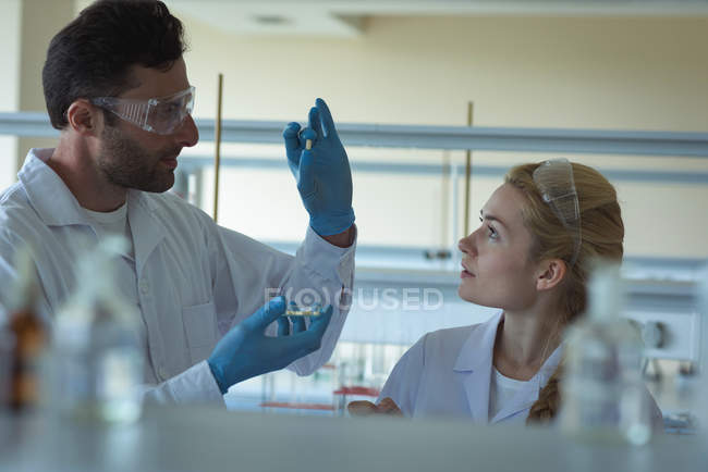 Attentive university students doing a experiment in laboratory — Stock Photo
