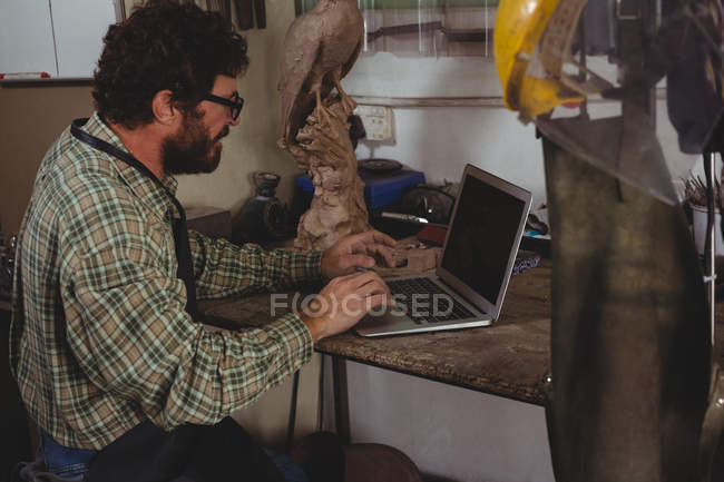 Aufmerksame Handwerker mit Laptop in Werkstatt — Stockfoto