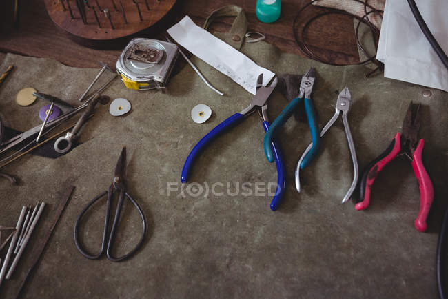 Various metal tools on wooden table in workshop — Stock Photo