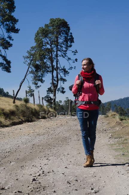 Wanderin mit Rucksack auf Feldweg unterwegs — Stockfoto