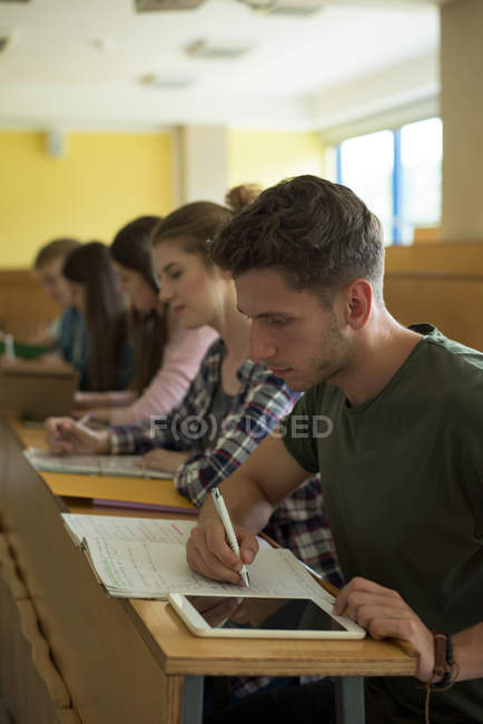 Молоді студенти навчаються за столом у класі. — стокове фото