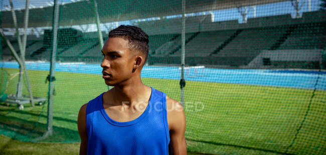 Side view of a mixed race male athlete practicing at a sports stadium, looking away from the camera. Track and Field Sports Training in Stadium. — Stock Photo