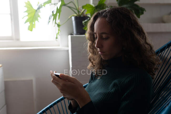 Mitte einer kaukasischen Frau, die Zeit zu Hause mit ihrem Smartphone verbringt. Lebensstil zu Hause isolierend, soziale Distanzierung in Quarantäne während Coronavirus covid 19 Pandemie. — Stockfoto