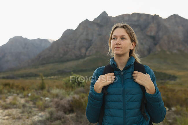 Porträt einer kaukasischen Frau, die sich bei einem Ausflug in die Berge gut amüsiert, warme Kleidung trägt, ihren Blick genießt, lächelt — Stockfoto