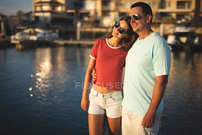 A Caucasian man and his teenage daughter standing on a jetty — Stock Photo