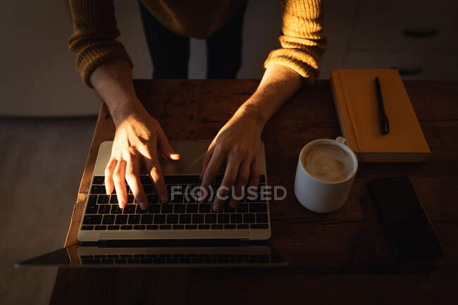 Mid section of woman spending time at home self isolating and social distancing in quarantine lockdown during coronavirus covid 19 epidemic, working in her kitchen, using her laptop computer. — Stock Photo
