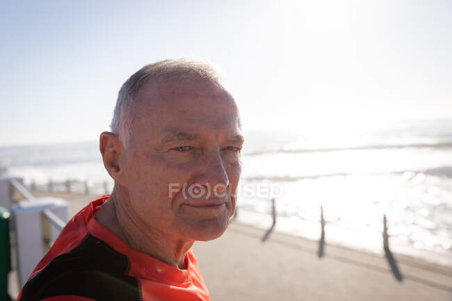 Portrait d'un homme caucasien âgé mature travaillant sur une promenade par une journée ensoleillée avec un ciel bleu, regardant la caméra sourire — Photo de stock