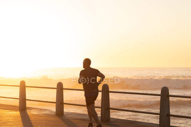 Погляд зрілого старшого кавказького чоловіка, який працює в сонячний день і біжить на заході сонця. — стокове фото